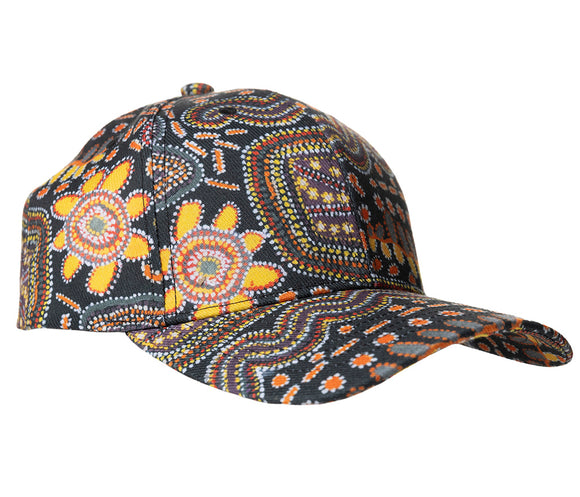 A baseball cap featuring Aboriginal artwork against a white background by Stan Brumby courtesy Yarliyil Arts. 