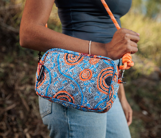 Close up photo of a person wearing a Rope Cross Body bag featuring artwork by Nigel Marshall from Warlukurlangu Artists
