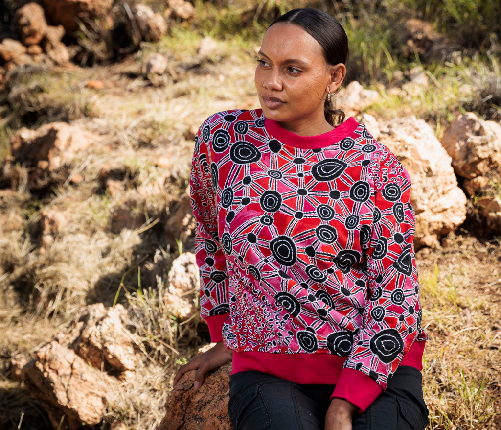 Model photographed outside wearing Bess Poulson Aboriginal Art Sweatshirt