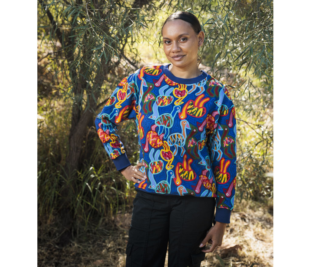Model photographed outside wearing Thelma Beeton Aboriginal Art Sweatshirt