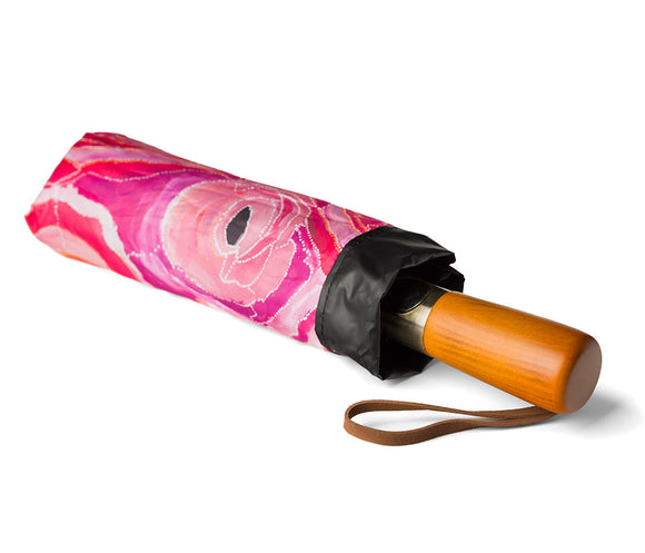 Fold Up Umbrella with wooden style handle and a black canopy photographed on a white background. Inside panels feature Aboriginal artwork by Steven Nelson courtesy Warlukurlangu Artists