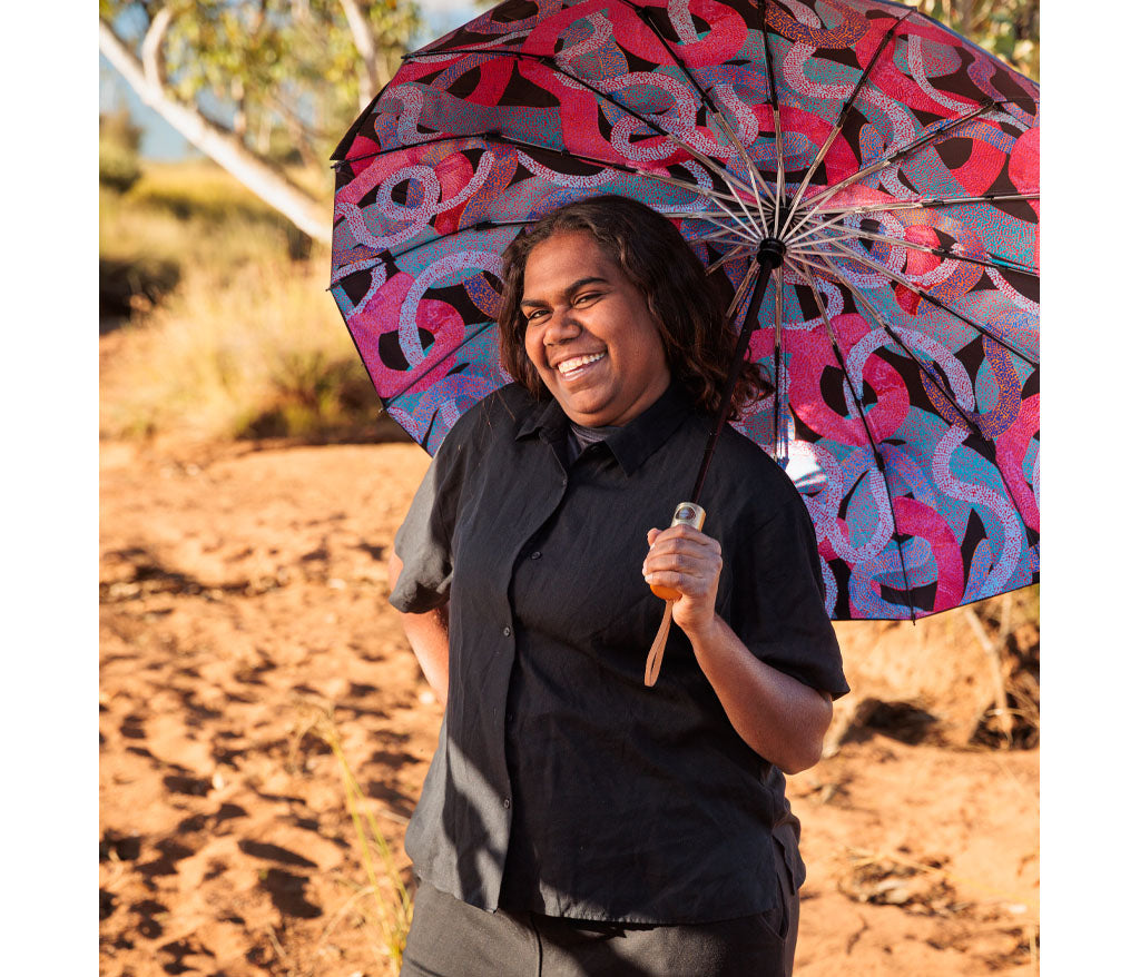 Fold Up Umbrella with Aboriginal artwork by Vanetta Hudson being held by the artist outside