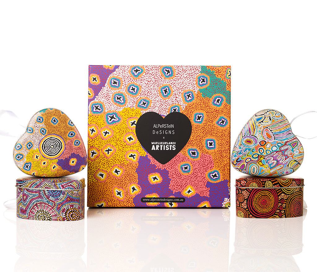 Colorful heart-shaped tins with a decorative box featuring Aboriginal art designs on a white background.