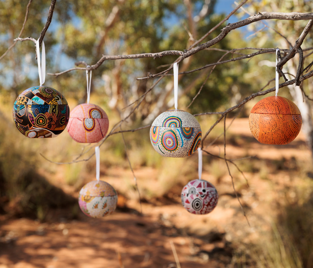 Aboriginal Art Christmas Bauble ornaments hanging from a branch outdoors