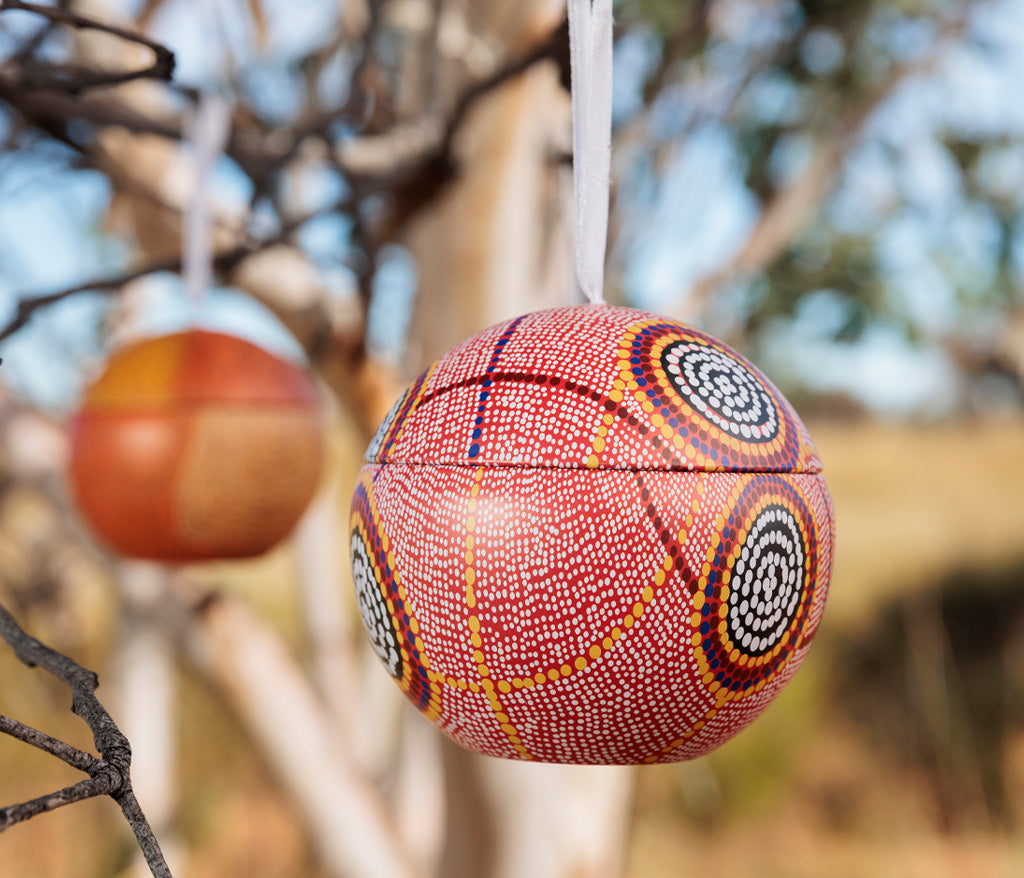 Debbie Brown Aboriginal Art Christmas Bauble hanging from a tree.
